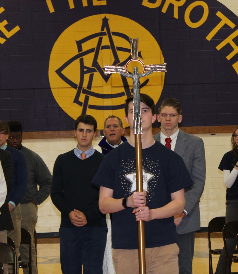 cba community celebrates feast of immaculate conception image of student holding cross