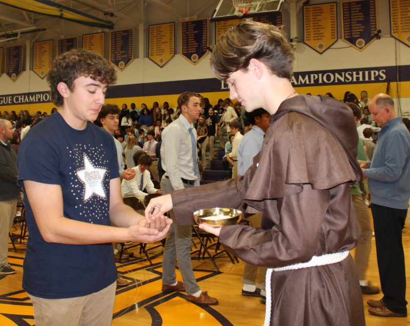 CBA Celebrates All Saints Day With Mass On Nov. 1 near syracuse ny image of student handing out food
